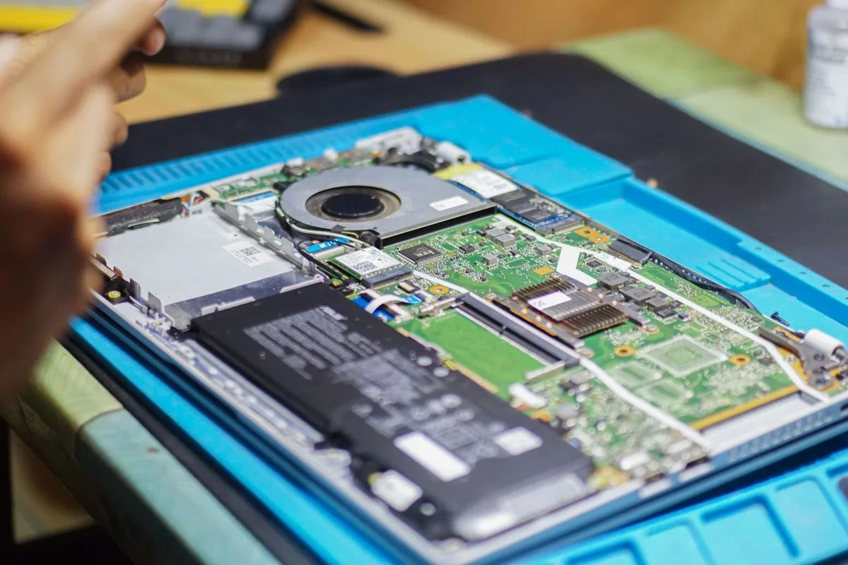 Geöffnetes Notebook mit freiliegender Hauptplatine auf einer Arbeitsfläche
