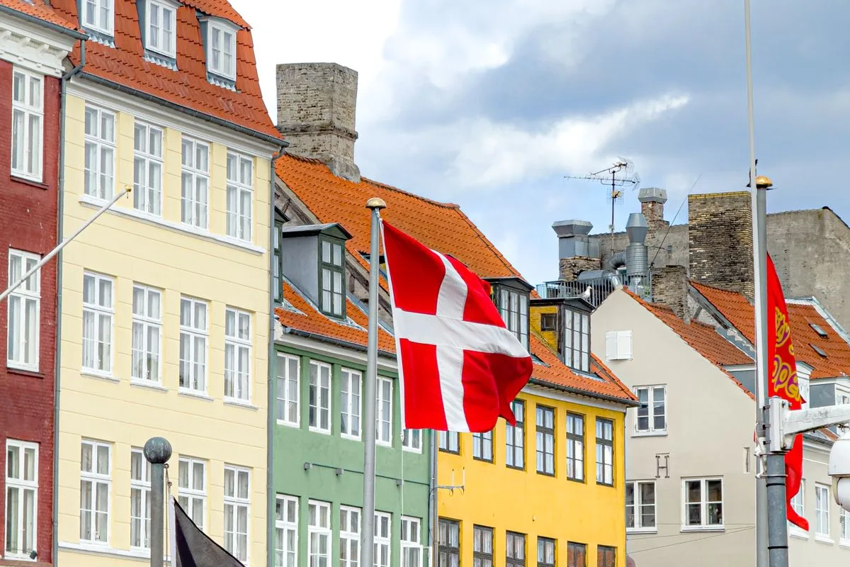 Bunte Häuserfronten am Kopenhagener Hafen mit dänischer Flagge