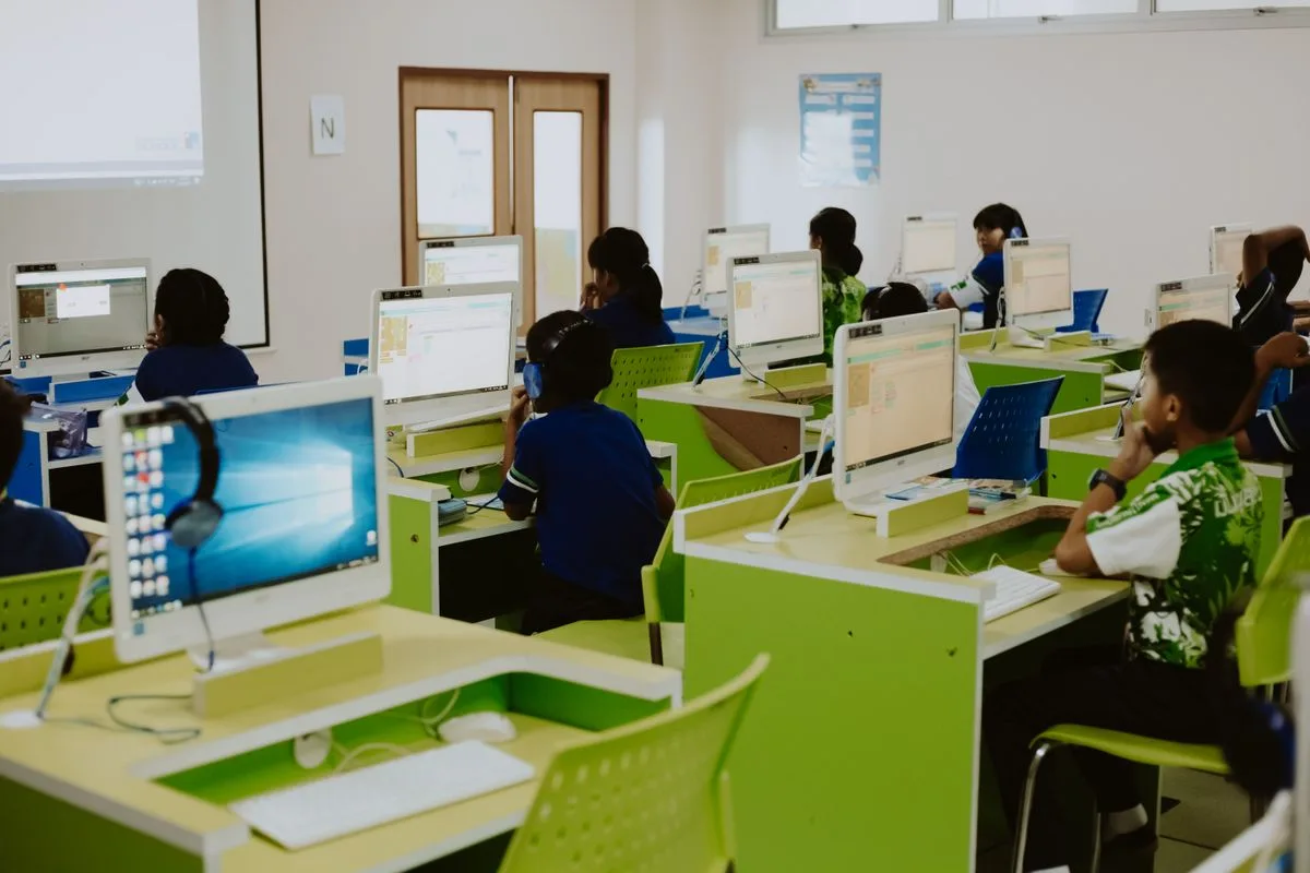 Klassenzimmer mit Computerarbeitsplätzen und Schülern